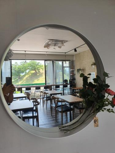 a mirror reflecting a dining room with tables and chairs at Gyeongju BonghwangMansion in Gyeongju