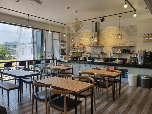 a restaurant with wooden tables and chairs and a kitchen at Gyeongju BonghwangMansion in Gyeongju