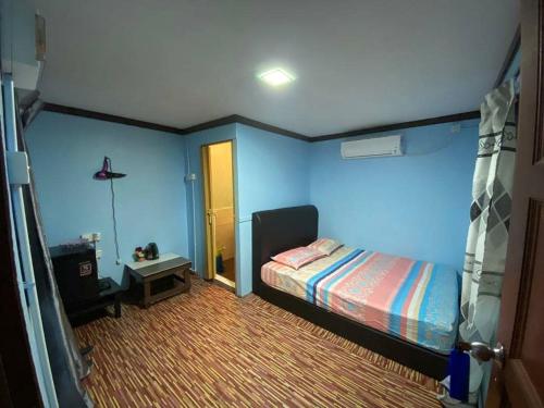 a bedroom with blue walls and a bed and a table at juara seaview chalet, kampung juara in Kampong Juara