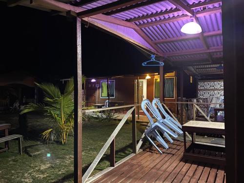 a deck with two chairs and a table and a tv at juara seaview chalet, kampung juara in Kampong Juara