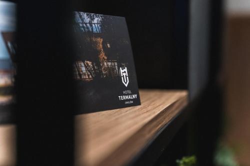 a book sitting on top of a wooden shelf at Hotel Termalny in Uniejow