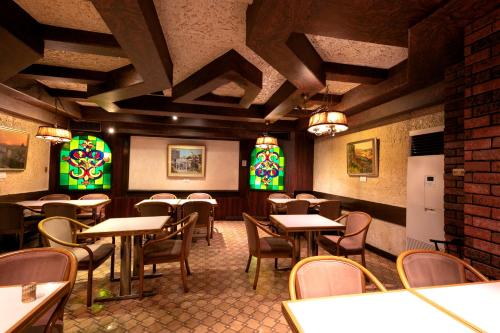 a restaurant with tables and chairs and stained glass windows at Hotel New Green in Nagaoka