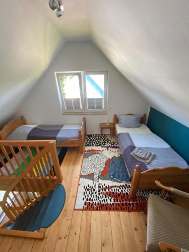 un dormitorio en el ático con 2 camas y una escalera en Haus Meere´s Stille, en Zingst