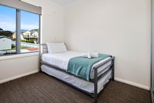 a small bedroom with a bed and a window at GRANITE BEACH HOUSE @ Bay of Fires in Binalong Bay