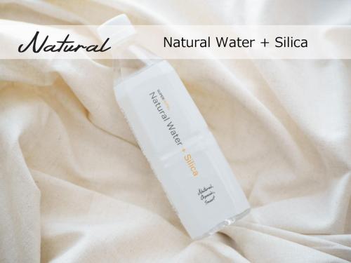 a white bottle ofnaturalnatural water silica sitting on a white cloth at Super Hotel Sendai Airport Inter in Natori