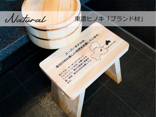 a wooden bench with a sign on it at Super Hotel Sendai Airport Inter in Natori
