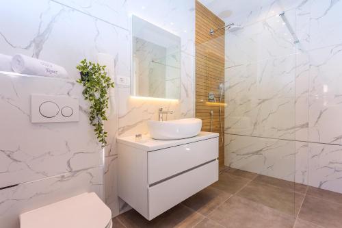 a white bathroom with a sink and a shower at Villa Topaz in Dugi Rat