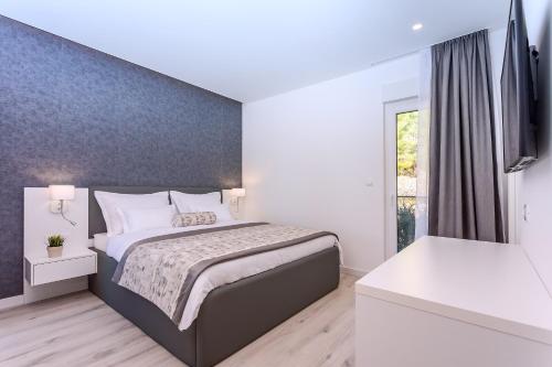 a bedroom with a bed with a blue wall at Villa Topaz in Dugi Rat