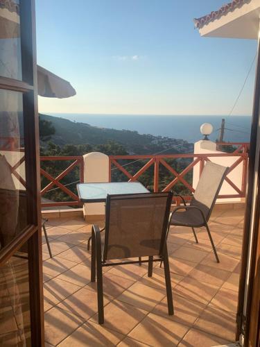 een patio met een tafel en stoelen op een balkon bij ΑΡΜΟΝΙΑ ΣΤΟΥΝΤΙΟ in Gialiskari