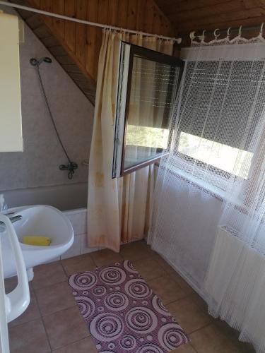a bathroom with a tub and a shower with a shower curtain at Kéktúrás-Tóra Nyíló Badacsonyi privát bérlemény in Badacsonytomaj