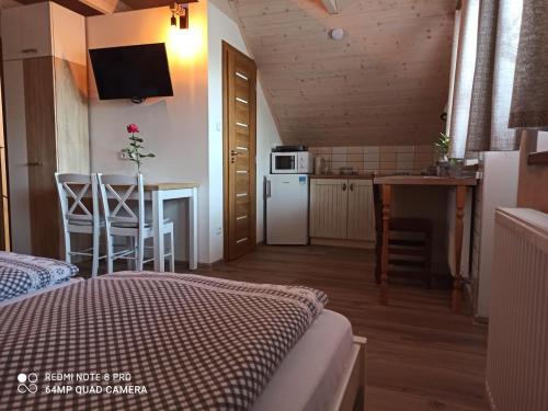 a room with a bed and a kitchen with a table at Sklípek u Svobodů in Velké Bílovice