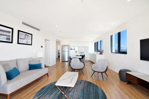 a living room with a couch and a table at Ruby Gold Coast by CLLIX in Gold Coast