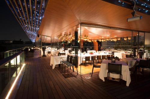 a restaurant with tables and chairs on a deck at night at Hotel Excelsior San Marco in Bergamo