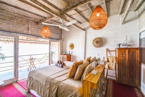 a bedroom with a large bed and a large window at Le Cliff Bali in Uluwatu