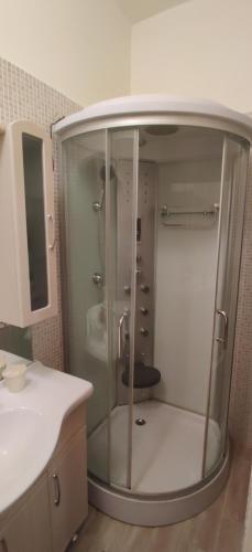 W łazience znajduje się szklana kabina prysznicowa i umywalka. w obiekcie Dorothy apartment near Budapest City Park w Budapeszcie