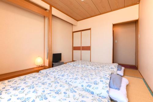 a bedroom with a bed and a television at Tabist Odakeya Ryokan Kashiwazaki in Kashiwazaki
