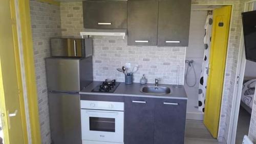 a small kitchen with a refrigerator and a sink at Le Chal Adret in Cardonville
