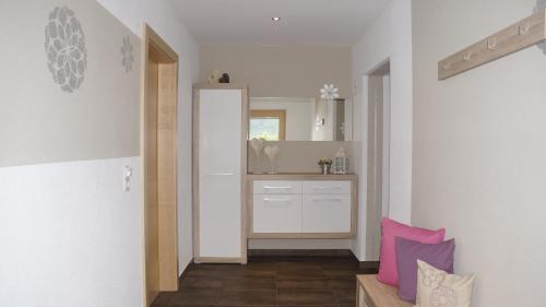um corredor com uma casa de banho com um lavatório e um espelho em Ferienwohnung Mario em Hippach