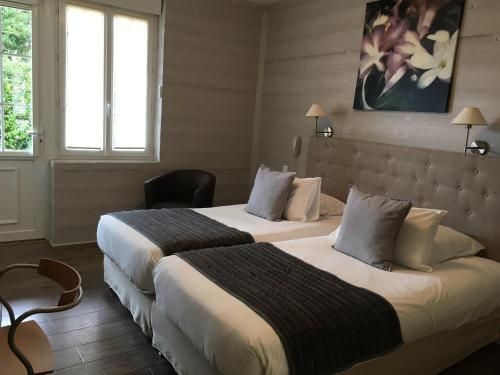 a hotel room with two beds and two windows at La Bonbonniere - Sure Hotel Collection by Best Western in Talant
