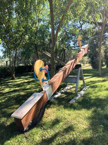 a park with a wooden slide in the grass at Il Casolare degli Alburni in Castelcivita