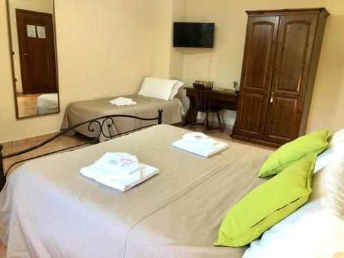 a hotel room with two beds and a desk at Il Casolare degli Alburni in Castelcivita
