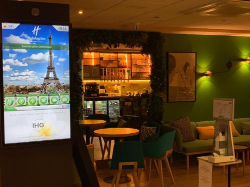 a living room filled with furniture and a tv at Holiday Inn Paris Montmartre, an IHG Hotel in Paris