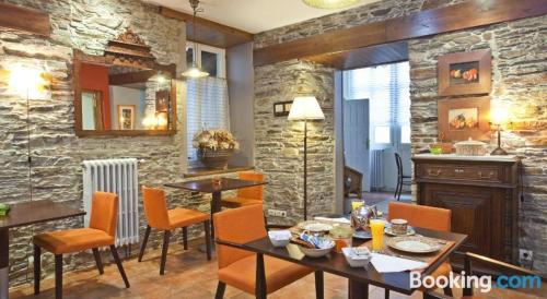 a dining room with a table and chairs and a stone wall at Casa Soto in Vegadeo