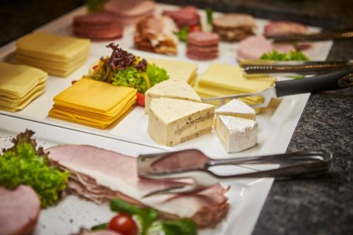 un piatto di alimenti con formaggio e altri alimenti di Hotel Gungau a Saalbach Hinterglemm