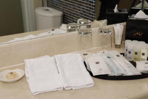 a bathroom counter with white towels on a counter top at Metropark Hotel Kowloon in Hong Kong