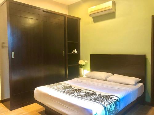 a bedroom with a large bed with a black cabinet at Tropical Home in George Town