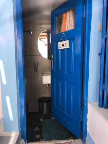 a blue door in a bathroom with a sign on it at Traditional House of Diafani in Karpathos Town
