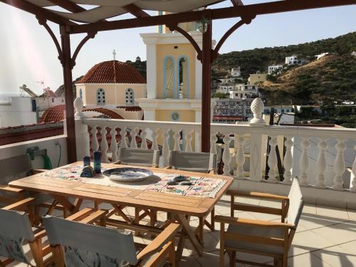 a wooden table and chairs on a balcony at Traditional House of Diafani in Karpathos