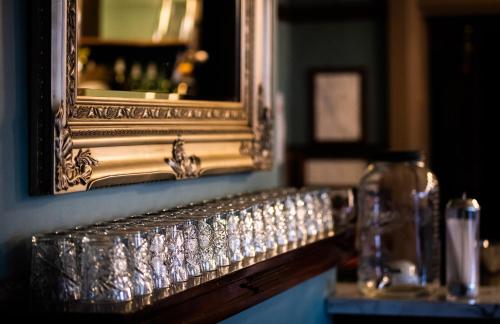 a mirror and a bunch of glasses on a counter at The Royal Hotel in West Wyalong