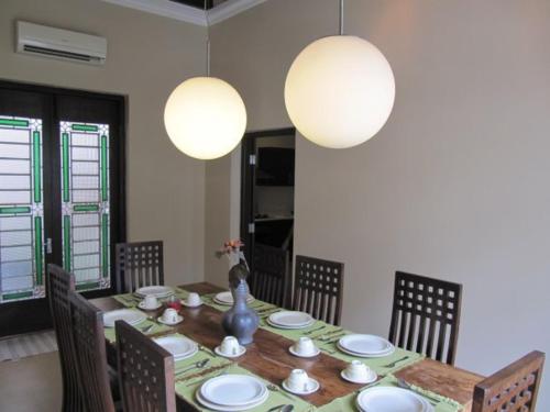 a dining room with a table with chairs and lights at Tropical Home in George Town