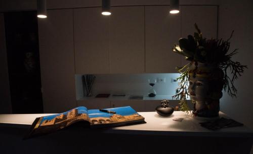 a kitchen counter with a book and a vase of flowers at Residenza del Castillo in Palermo