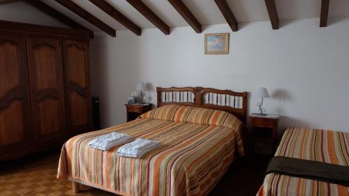 サン・ジャン・ピエ・ド・ポルにあるシャンブレ ドート ガリコイツのベッドルーム1室(ベッド2台、キャビネット付)