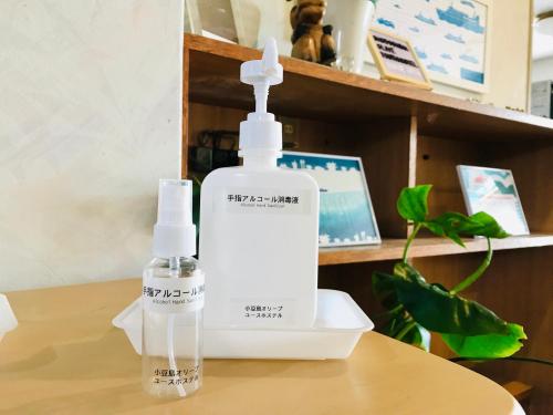 two bottles of mouthwash sitting on a wooden table at Shodoshima Olive Youth Hostel in Shodoshima