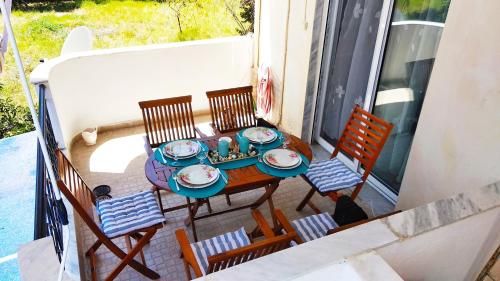 a table and chairs on a balcony with a meal on it at Apartment Marina 1 in Asprovalta