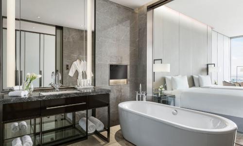 a bathroom with a bath tub and a bed at Niccolo Changsha in Changsha