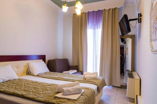 a hotel room with a bed and a television at Hotel Zografos in Paralia Katerinis