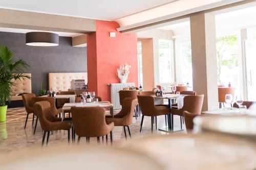 a dining room with tables and chairs and windows at Hotel Conca D'Oro ***S in Garda