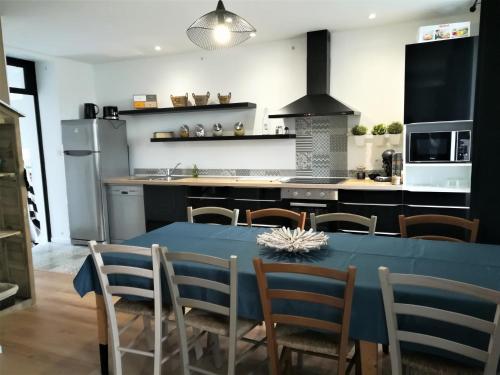 une cuisine et une salle à manger avec une table bleue et des chaises dans l'établissement Le gîte Donemat, à Ploudalmézeau