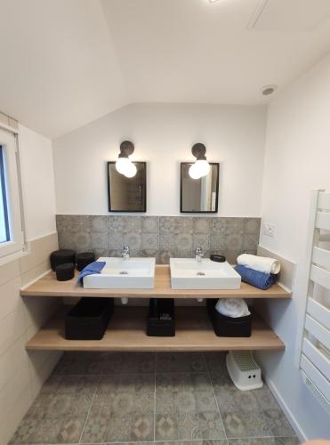 une salle de bain avec deux lavabos et deux miroirs dans l'établissement Le gîte Donemat, à Ploudalmézeau