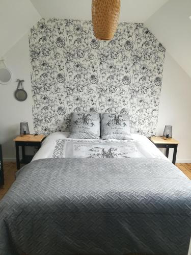 une chambre avec un lit avec un papier peint fleuri dans l'établissement Le gîte Donemat, à Ploudalmézeau