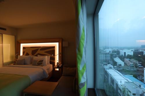 a hotel room with two beds and a large window at Novotel Chennai OMR in Chennai