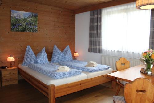 a bedroom with a bed with blue pillows on it at Haus Strobler in Going