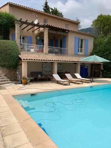 a villa with a swimming pool in front of a house at Villa Magnolia in Seillans