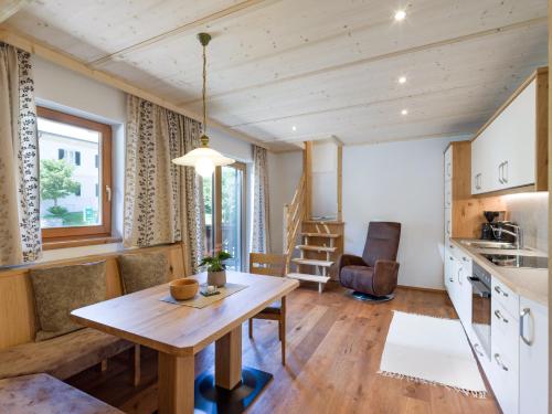 a kitchen and living room with a wooden table at Appartement Hinterholzer in Going