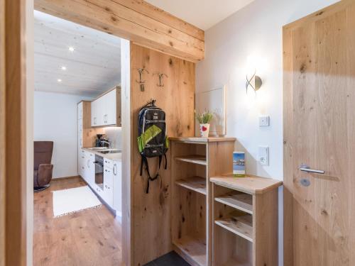 a kitchen with wooden walls and a door to a room at Appartement Hinterholzer in Going