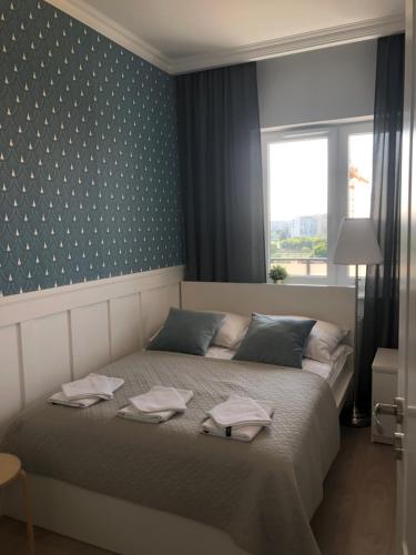 a bedroom with a bed with two towels on it at Apartament Grażyna Stańczyka in Warsaw